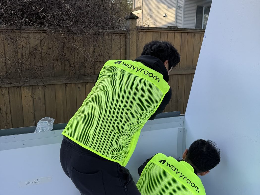 Wavyroom crew assembling panels in a customer's backyard