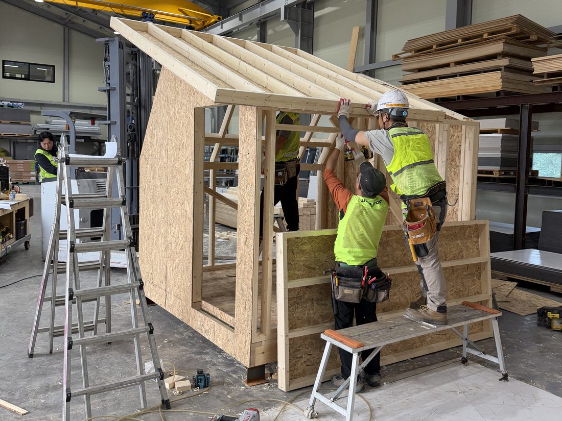 Wavyroom crew framing a module inside the factory in Korea