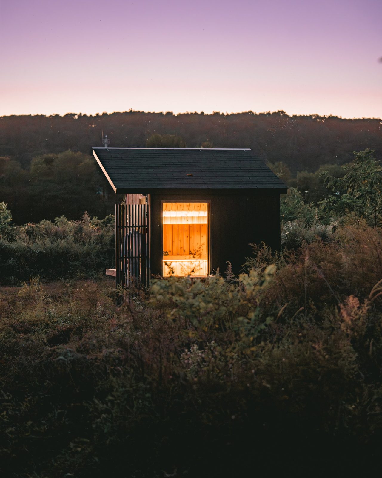 Wavyroom sauna at dusk, window glowing