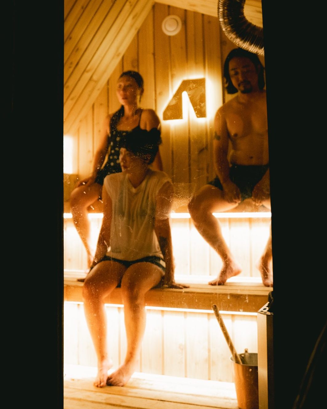 People on the cedar benches inside a Wavyroom sauna